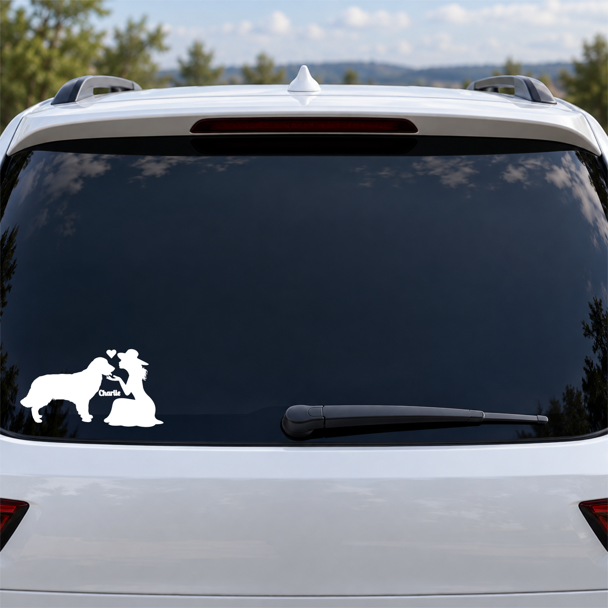 White personalized lady and dog Charlie vinyl decal shown on a tinted SUV rear window